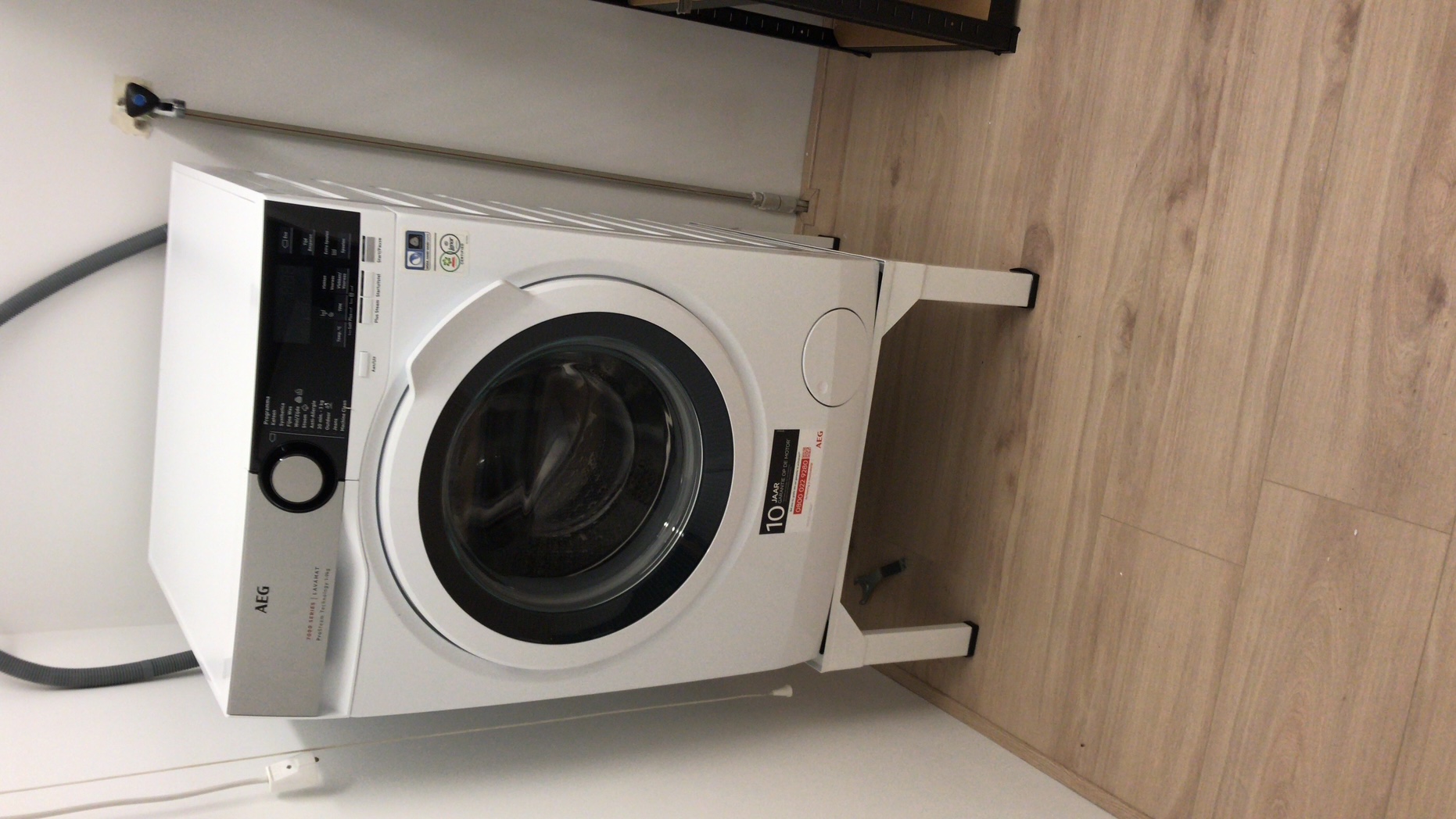 Wasmachine netjes aangesloten en waterpas geplaatst in een woning in Hoofddorp